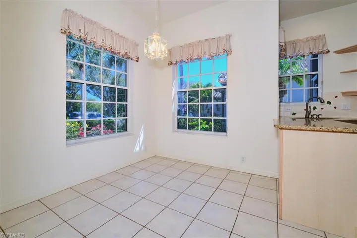 Unfurnished dining area with a chandelier and light tile patterned floors
