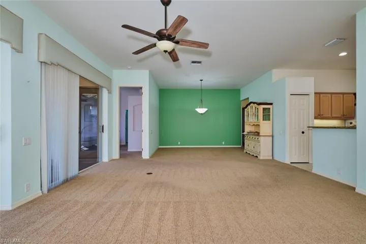 Unfurnished living room with ceiling fan and light colored carpet