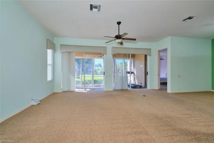 Unfurnished living room featuring carpet floors and a ceiling fan