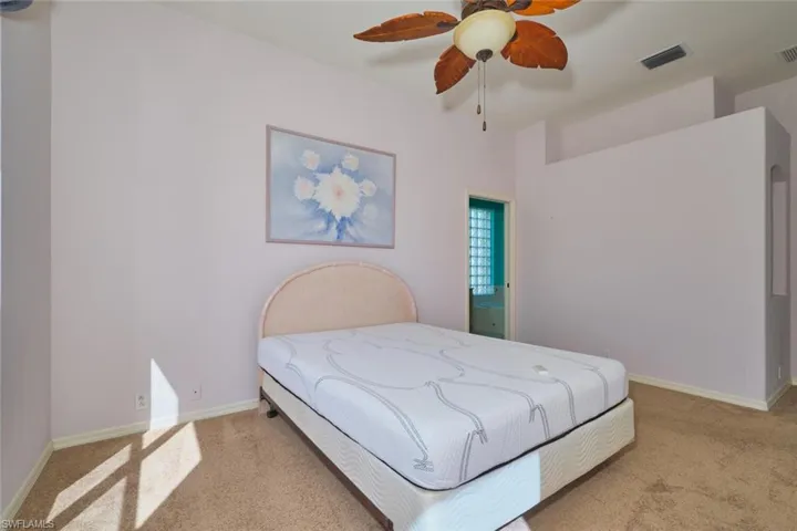 Bedroom with light colored carpet and ceiling fan