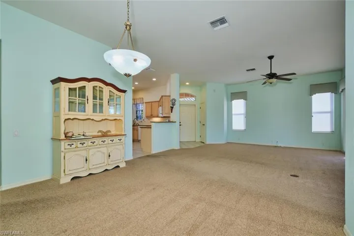 Unfurnished living room featuring light carpet, ceiling fan, and recessed lighting