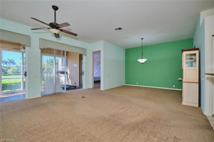 Unfurnished living room with light carpet and a ceiling fan