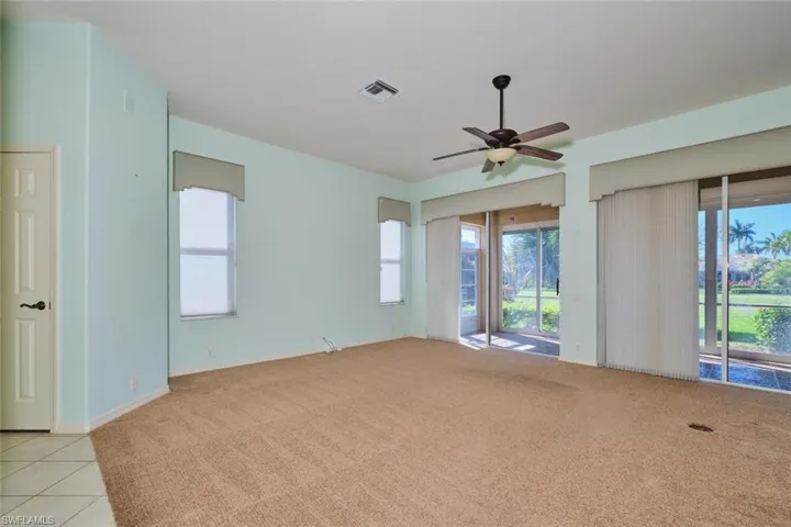 Empty room featuring a ceiling fan and light carpet