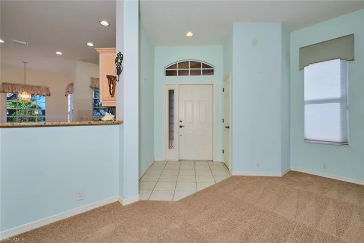Entryway with light carpet, recessed lighting, and light tile patterned flooring