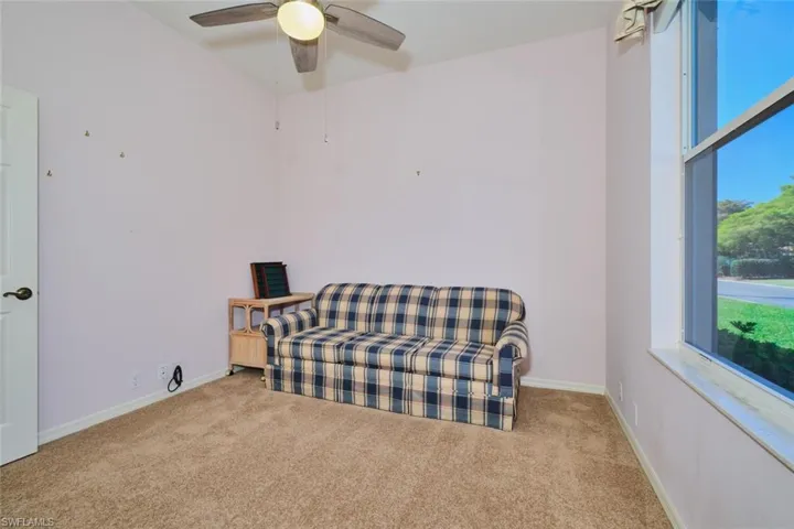 Living area with carpet and a ceiling fan