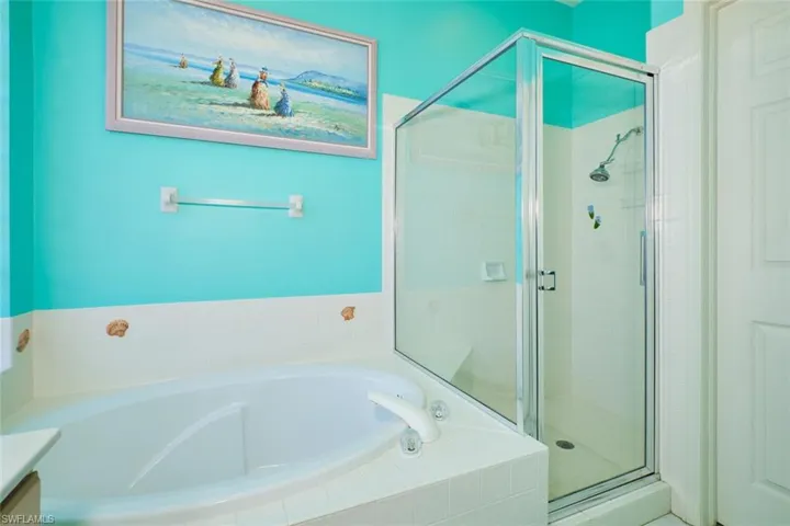 Bathroom featuring a bath, a shower stall, and vanity