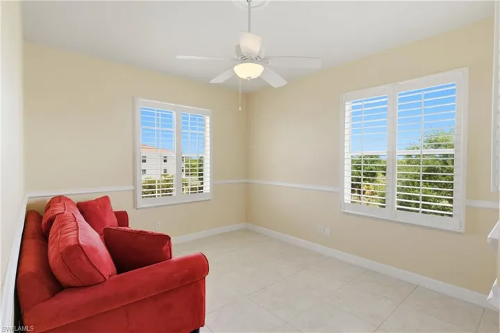Sitting room featuring healthy amount of natural light, light tile patterned floors, and a ceiling fan