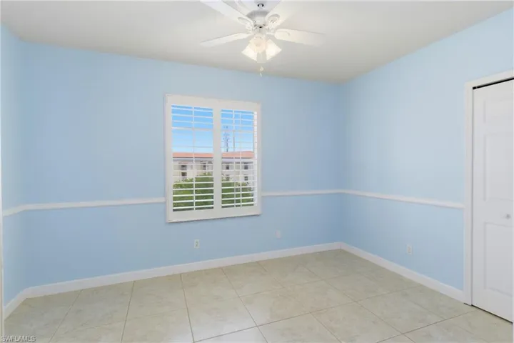 Unfurnished room with ceiling fan and light tile patterned floors