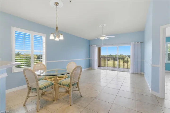 Dining space featuring lofted ceiling, light tile patterned floors, and a ceiling fan