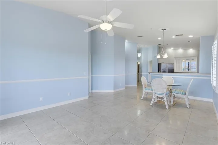 Dining area with light tile patterned floors, ceiling fan, recessed lighting, and lofted ceiling