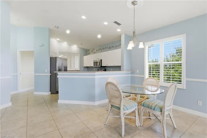 Dining area with vaulted ceiling, recessed lighting, and light tile patterned flooring