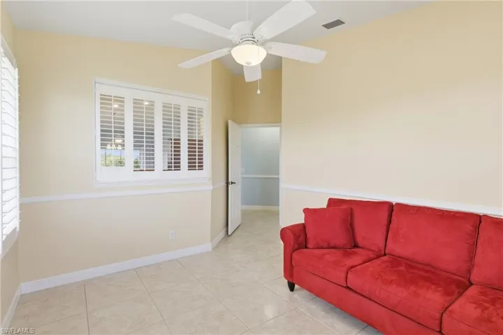 Living area featuring light tile patterned floors, ceiling fan, and plenty of natural light