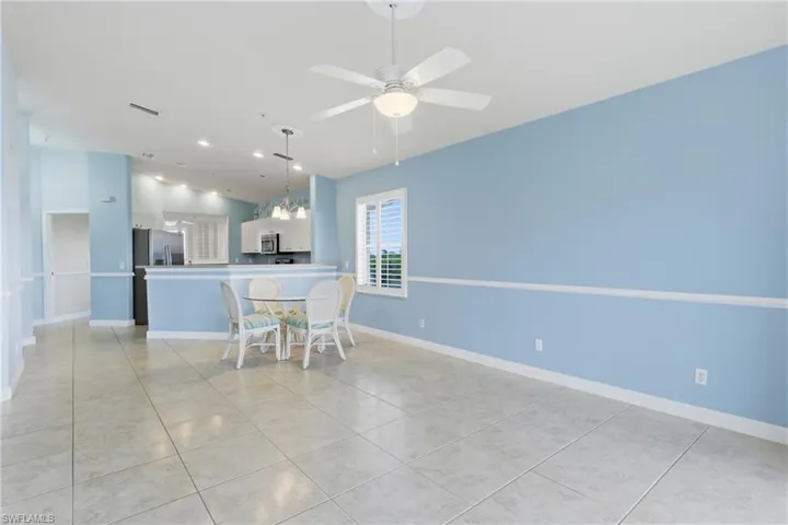 Dining space featuring light tile patterned flooring, suspended lighting, and ceiling fan
