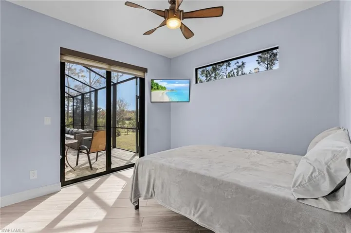 Bedroom featuring ceiling fan, access to exterior, and light hardwood / wood-style flooring