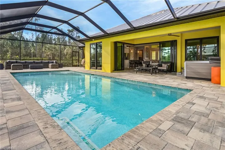 View of pool with an outdoor living space, a lanai, a patio, and ceiling fan