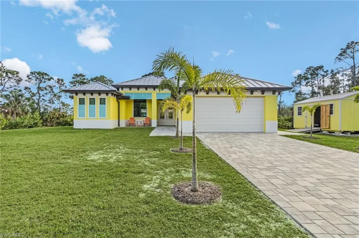 View of front facade featuring a garage and a front lawn