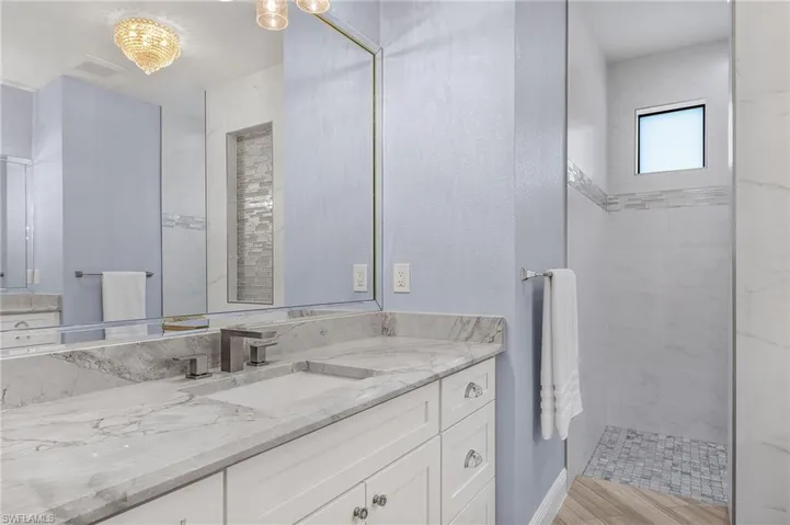 Bathroom featuring a tile shower and vanity