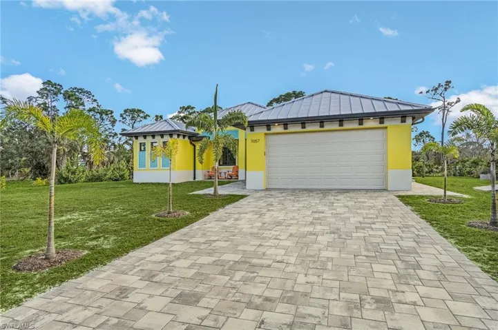 View of front of house with a garage and a front lawn