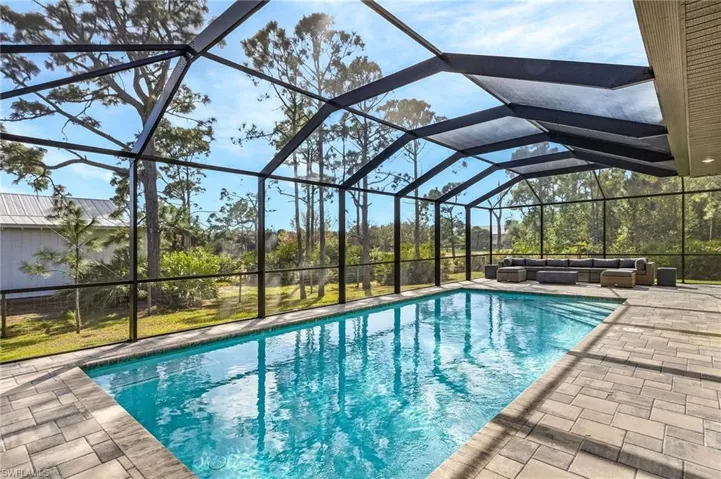 View of swimming pool featuring a lanai, an outdoor hangout area, and a patio