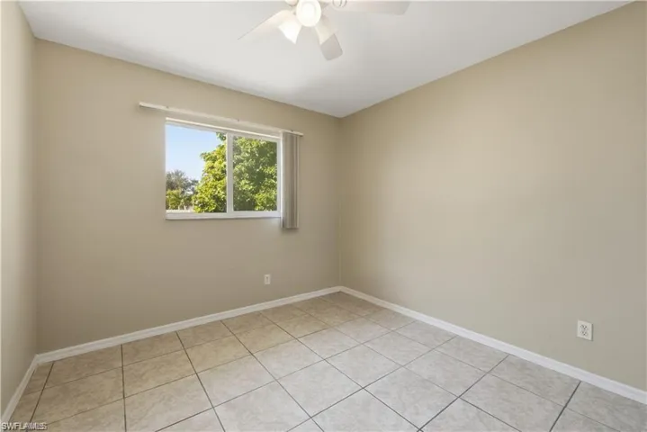 Spare room with a ceiling fan and light tile patterned floors