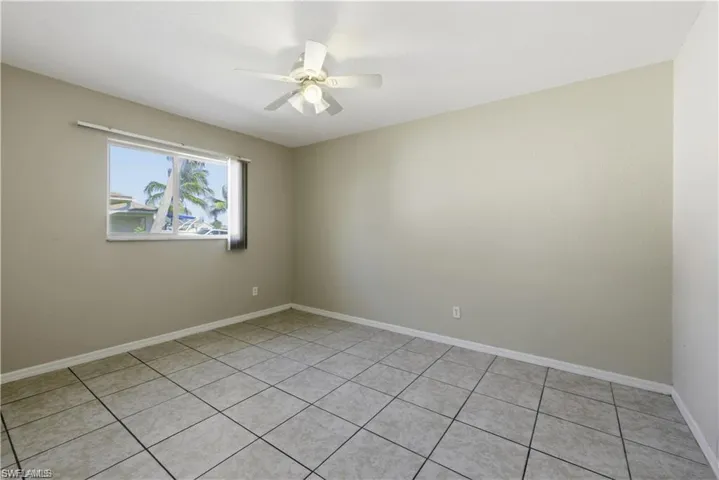 Spare room with a ceiling fan and light tile patterned flooring