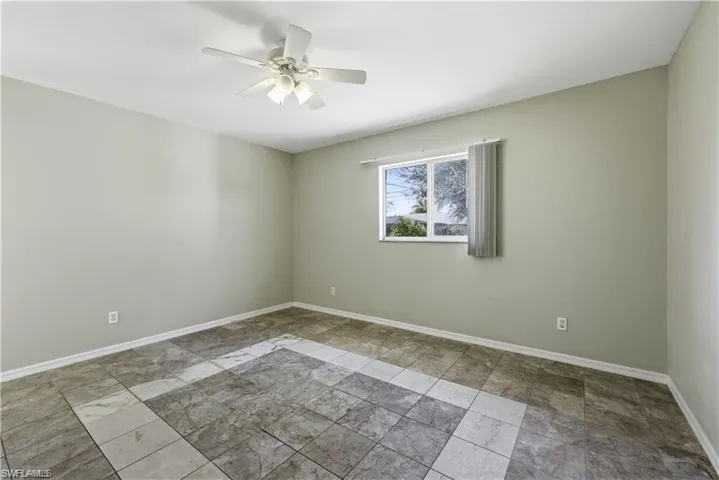 Spare room featuring ceiling fan and light stone finish flooring