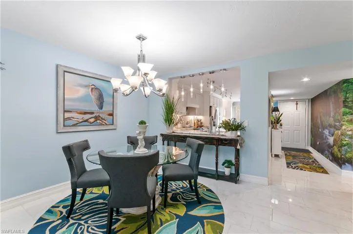 Dining area featuring a contemporary chandelier, light blue wall finishes, and porcelain flooring