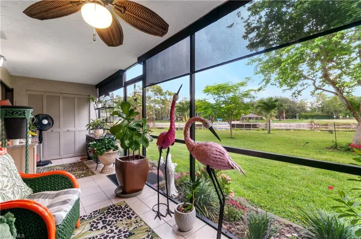 Screened patio lanai featuring tile flooring, a ceiling fan, and accordion-style storage doors