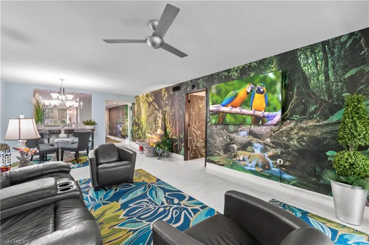 Living area featuring a modern ceiling fan, recessed lighting, and a prominent mural wall