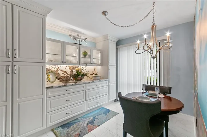 Built-in cabinetry with glass uppers and under-cabinet lighting, complemented by Quartz  stone backsplash and countertops