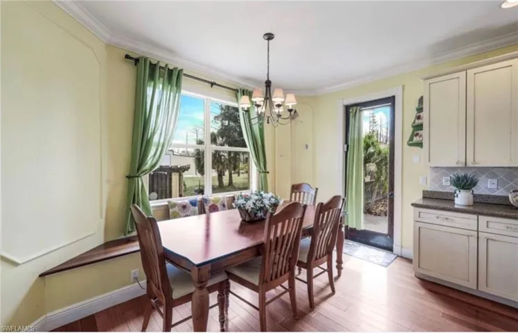 Dining space with a notable chandelier, plenty of natural light, and hardwood / wood-style floors