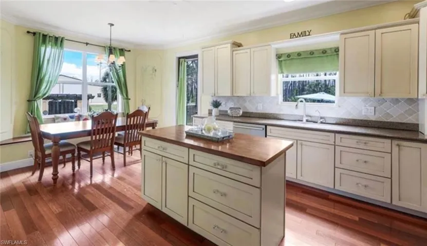 Kitchen with sink, a healthy amount of sunlight, hardwood / wood-style flooring, and tasteful backsplash