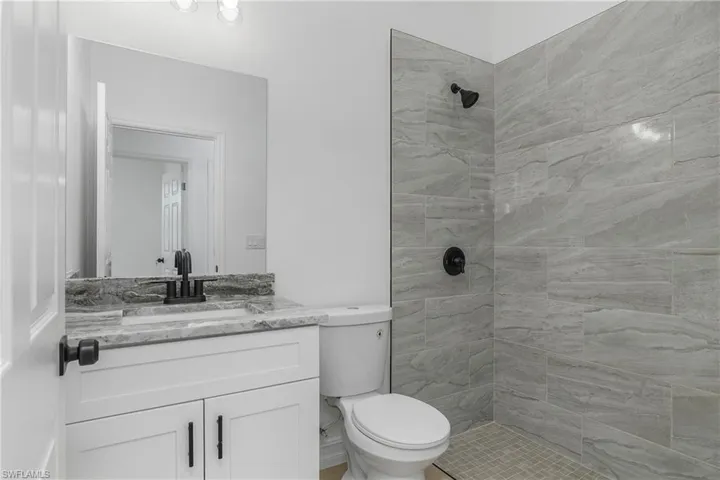 Guest bathroom with vanity and tiled shower