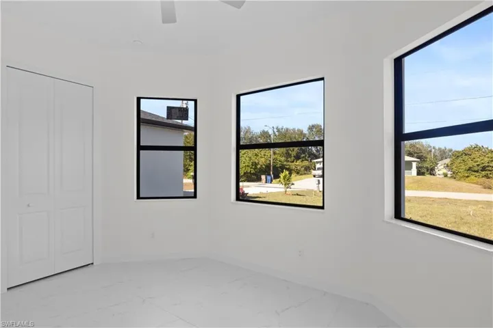 Unfurnished bedroom with light marble finish floors, ceiling fan, and a closet