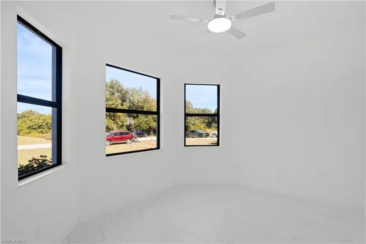 Unfurnished bedroom with light marble finish flooring and a ceiling fan