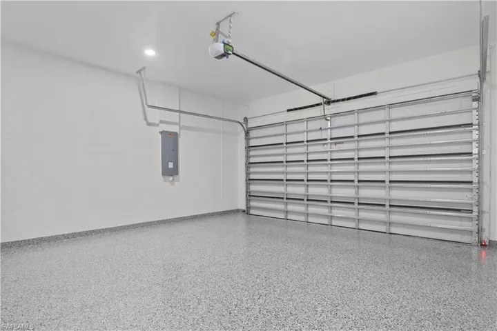 Garage featuring electric panel and a garage door opener