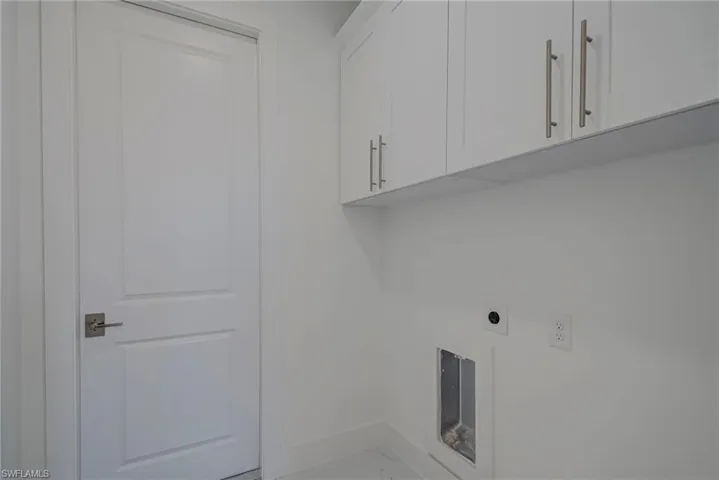 Laundry room featuring cabinet space, electric dryer hookup, and marble look tile flooring