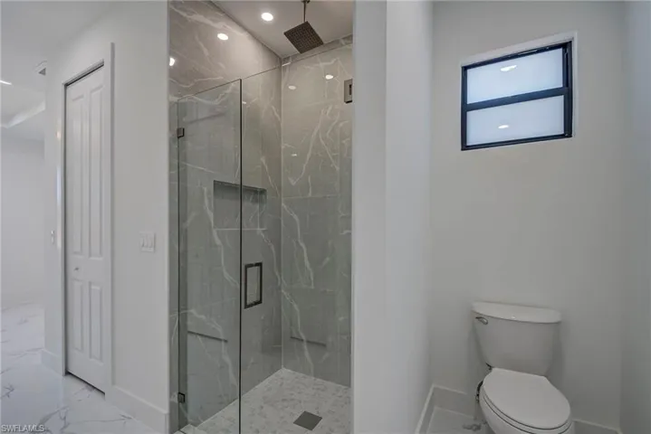Bathroom featuring marble finish floors, a marble finish shower, a closet, and recessed lighting