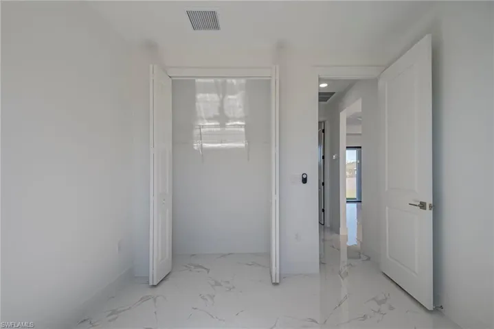 Unfurnished room with baseboards and light marble finish flooring