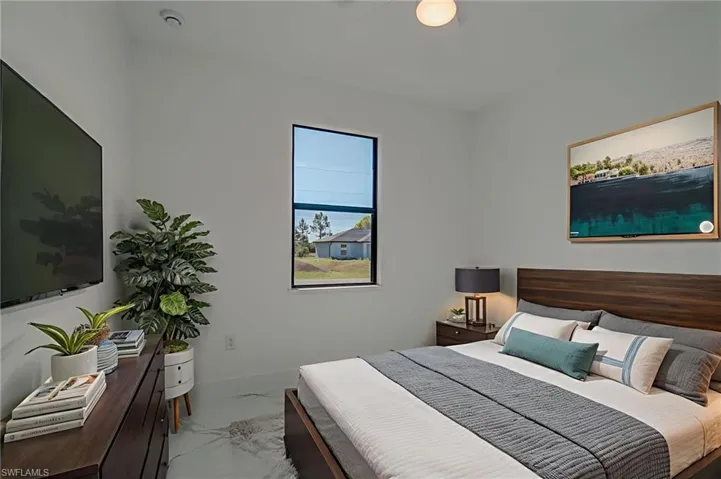 Bedroom with marble finish flooring and baseboards