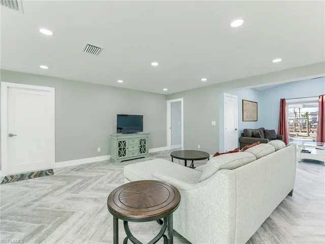 Access to garage and primary bedroom from living space, den area seen the the right
