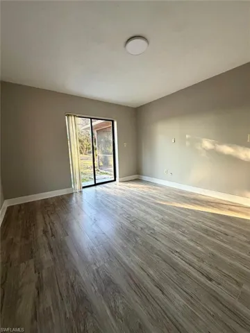 Unfurnished room with dark wood finished floors and baseboards