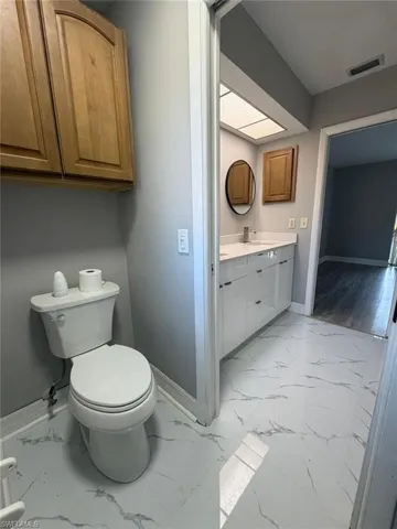 Bathroom featuring vanity and light marble finish flooring