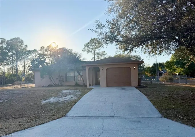 View of front of house with stucco siding, concrete driveway, and a garage