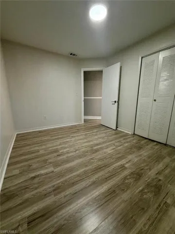 Unfurnished bedroom featuring wood finished floors and a closet