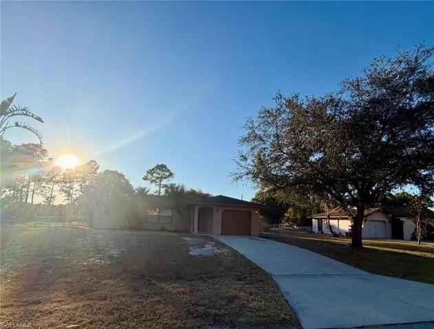 View of front of home featuring concrete driveway, an attached garage, and stucco siding