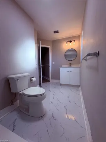 Bathroom featuring vanity and light marble finish flooring