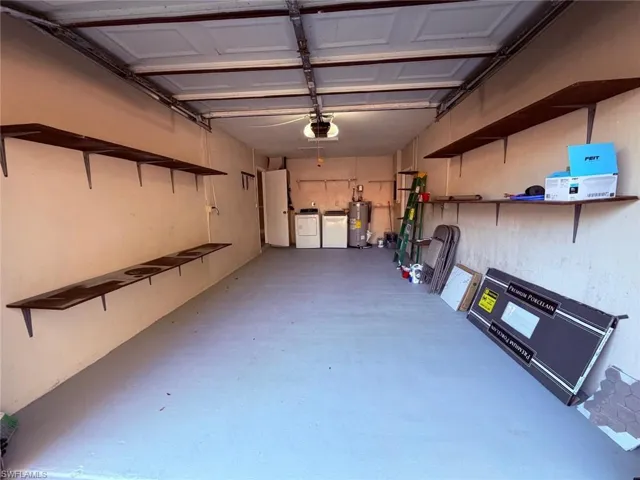 Garage featuring washer and clothes dryer, water heater, and a garage door opener