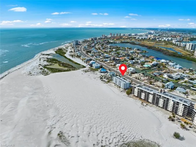 Birds eye view of property featuring a water view and a beach view