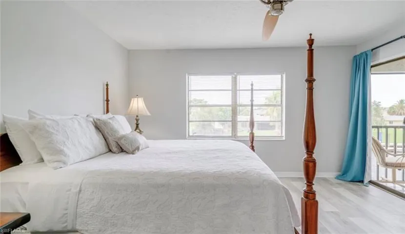 Bedroom featuring access to exterior, light wood-style floors, multiple windows, and a ceiling fan